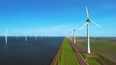 Yeşil enerji ve enerji geçişinde sürdürülebilirliğin sembolü olan yel değirmeni türbinlerinin ve Ijsselmeer 'in yanındaki Hollandalı hendeğin çarpıcı manzarasını araştırın.