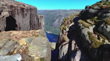 Kjeragbolten muhteşem Lysefjorden manzarası sunuyor, Norveç 'te kesinlikle görülmesi gereken bir yer, Kjerag Lysefjorden Lysebotn' daki kayanın üzerinde duran kadın.