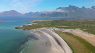 Bu hava çekimi, Norveç Lofoten Adaları 'nın göz kamaştırıcı güzelliğini gözler önüne seriyor, el değmemiş plajlar ve yüksek dağlar, maceracılar ve seyahat meraklıları Kolbedeliden Sahili için mükemmel.