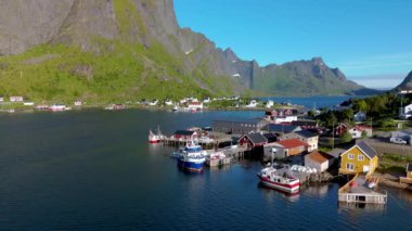 Norveç, Lofoten Adaları 'ndaki görkemli dağlarla ve berrak mavi sularla çevrili, macera ve keşif için mükemmel bir limanın nefes kesici manzarasının tadını çıkarın.