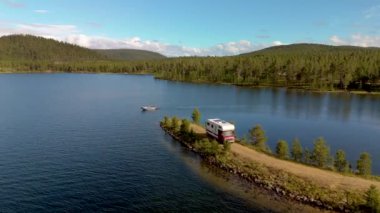 Norveç 'te çekilen bu nefes kesici hava görüntüsü yemyeşil bir gölün etrafını sardığını ve bir karavan karavanıyla kapladığını gösteriyor. Seyahat ve açık hava maceraları için mükemmel bir mekan.