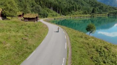 Norveç 'in dinginliğini keşfedin. Işıl ışıl bir göl kenarında, yeşil ve büyüleyici kulübelerle çevrili manzaralı bir yol, sizi doğa sükunetine, Lovatnet Gölü Lodal Vadisi' ne davet ediyor.