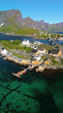 Norveç 'in Lofoten Adaları' nda, berrak suların görkemli dağlarla buluştuğu ve tüm ziyaretçiler için büyüleyici bir manzara yaratan geleneksel bir köyün çarpıcı güzelliğini keşfedin.