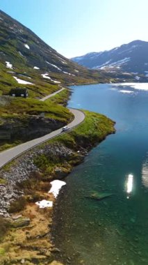 Norveç 'te sakin bir göl tarafından virajlarla çevrili muhteşem bir yol manzarası. Görkemli dağlar ve yeşillikler, ünlü Geirangerfjord' un yanında, doğa severler için mükemmel.