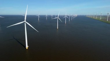 Hollanda 'da sürdürülebilir yel değirmeni türbinlerini keşfetmek, enerji geçişini sağlamak ve küresel ısınmayla mücadele etmek. Hollanda 'daki Ijsselmeer gölündeki yel değirmeni çiftliği.