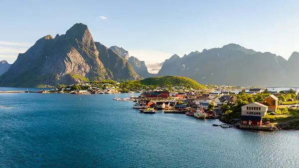 stock image Explore the picturesque village of Reine in Norways Lofoten Islands, where majestic mountains and tranquil waters create an ideal backdrop for adventurers and nature lovers