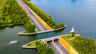 Bereketli yeşillik ve sayısız yelkenlinin çerçevelediği canlı bir rıhtım yolunun sersemletici görüntüsü.