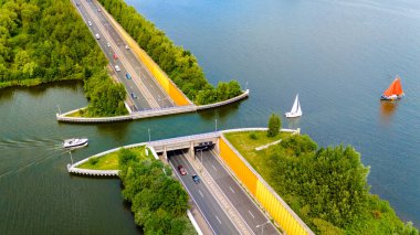 Veluwemeer Aqueduct Hollanda otoyolun yukarısındaki bir kanaldan geçen yelkenli tekneleri ile bu çarpıcı hava yakalama gösterileri karmaşık yol kesişimleri ve canlı su aktiviteleri