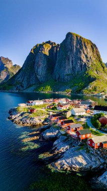 Havadan çekilen görüntü, Norveç 'in büyüleyici Lofoten Adaları' ndaki görkemli tepeler ve berrak sularla çevrili büyüleyici bir balıkçı kasabası olan Hamnoy Reine 'nin pitoresk özünü yakalıyor.