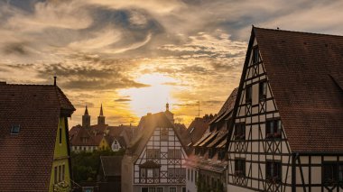 Güneş ufkun altına batarken, altın ışık Rothenburg ob der Tauber 'in yarı keresteli evlerini yıkıyor ve bu ortaçağ kasabasının alacakaranlıktaki sihrini yansıtan pitoresk bir manzara yaratıyor..
