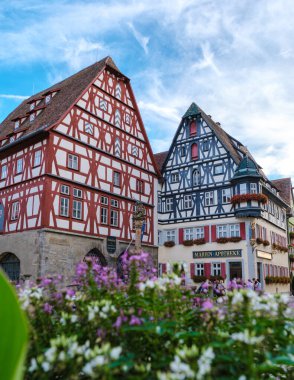 Rothenburg ob der Tauber, Almanya 25 Ağustos 2024, renkli yarı keresteli evler pamuk şeker bulutlarına karşı gururla duruyor.