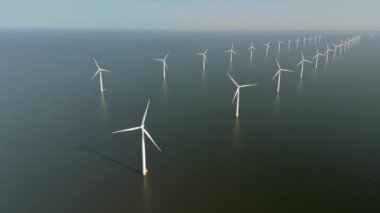 Hollanda, Flevoland 'daki geniş yeldeğirmeni türbinlerini araştırın. Küresel ısınmaya karşı yürütülen mücadelede yeşil enerji ve sürdürülebilirliğe doğru önemli bir kaymayı temsil ediyor..