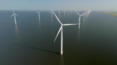 Hollanda 'nın Flevoland kentindeki etkileyici yel değirmeni türbinlerini keşfedin. Küresel ısınmayla mücadelede yeşil enerjiye geçişi ve yenilenebilir enerji kaynaklarının önemini vurgulayın.