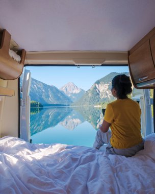 Bir gezgin sakin bir sabah geçirir, Avusturya 'daki Plansee' nin durgun sularına bir karavan, karavan ya da karavan ile bakar.