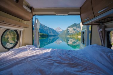 Huzurlu bir karavana yerleştirilmiş Plansee Avusturya 'nın çarpıcı bir manzarası şafakta gözler önüne seriliyor. Aynaya benzeyen göl görkemli dağları yansıtır. Huzuru ve macerayı doğanın kucaklamasına davet eder..