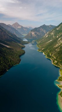 Avusturya Alpleri 'nin göbeğine yerleşen Plansee, görkemli dağlarla çevrili büyüleyici turkuaz sularını gözler önüne seriyor. Sırtlar gölü berrak mavi bir gökyüzünün altına kuruyor ve huzurlu bir kaçış sunuyor..