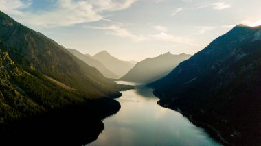 Plansee 'nin sakin suları, altın saatin sıcacık parıltısıyla yıkanan etrafındaki dağları yansıtır. Doğa çarpıcı paletini, keşif ve sükunetini sergiliyor..