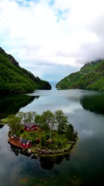 Norveç 'te bereketli tepeler ve sakin fiyortlarla çevrili sakin bir ada inzivası. Günlük hayattan uzakta huzur ve rahatlık arayan doğa severler için ideal bir kaçış, Lovrafjorden bir göldeki kırmızı kulübe.