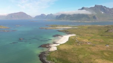 Norveç 'in Lofoten Adaları' nın nefes kesen hava görüntüleri arka planda manzaralı plajlar, turkuaz sular ve görkemli dağlar sergiliyor. Seyahat meraklıları için mükemmel..