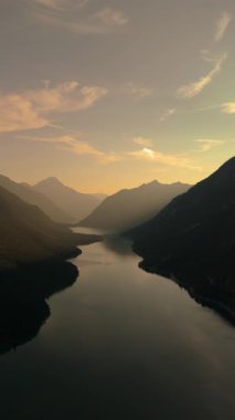 Güneş batarken, Tyrolean Alplerindeki Plansee Gölü 'nün sakin sularına canlı renkler saçar.