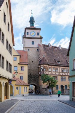 Rothenburg ob der Tauber, Almanya, 25 Ağustos 2024, Rothenburg ob der Tauber 'in huzurlu sokaklarında gezinen ziyaretçiler, tarihi mimariye ve canlı renklere hayret ediyorlar.