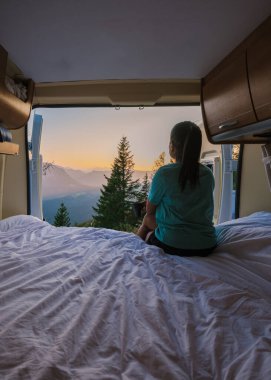 Hallstatt üzerinde şafak sökerken bir gezgin bir karavanın içindeki bir yatakta huzur içinde oturur ve çarpıcı dağ manzarasına bakar. Güneşin doğuşu huzurlu manzaranın üzerine ılık bir parıltı saçar..