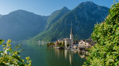 Sabahın erken saatlerinde, büyüleyici köy gölün sakin sularını yansıtırken, Hallstatt 'ın üzerine altın bir parıltı saçıyor. Etrafı görkemli dağlarla çevrili, huzur dolu bir manzara sunuyor..