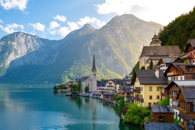 Görkemli dağların arasına yerleşen Hallstatt, sakin göl boyunca büyüleyici mimarisini sergiliyor. Gün sona ererken altın güneş ışığını yansıtıyor. Büyüleyici bir an bekliyor..
