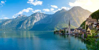 Avusturya Hallstatü 'sü, görkemli dağların arasına kurulmuş, Hallstatt, gölün üzerine yansıyan sabah ışığıyla uyanıyor.
