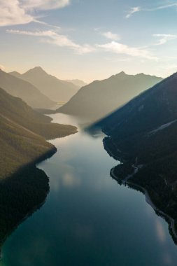 Yumuşak sabah ışığında yıkanan Plansee 'nin huzurlu suları etrafındaki görkemli dağları yansıtıyor.