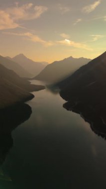 Günbatımında Avusturya 'nın Tyrolean Alplerinde Plansee Gölü' nün dingin güzelliğini gösteren bir hava manzarası var.