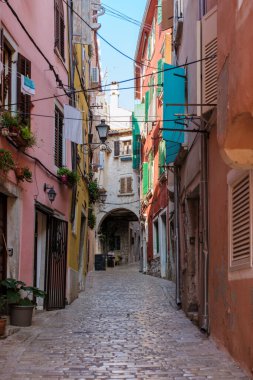 Rovinj 'de, pastel renkli binaların kaldırım taşı yolu boyunca uzandığı pitoresk bir ara sokak keşfi çağrıştırıyor. Gün ışığı duvarlar arasında dans ederken çamaşırhane rüzgarda çırpınıyor..