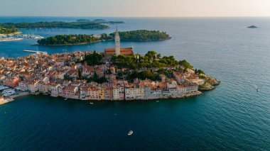 Rovinj, kıyı şeridini saran renkli binalarıyla gün batımında görkemli bir şekilde ayakta duruyor. Turkuaz sular, bu büyüleyici Hırvat kasabasının sıcak ve davetkar keşfini yansıtıyor..
