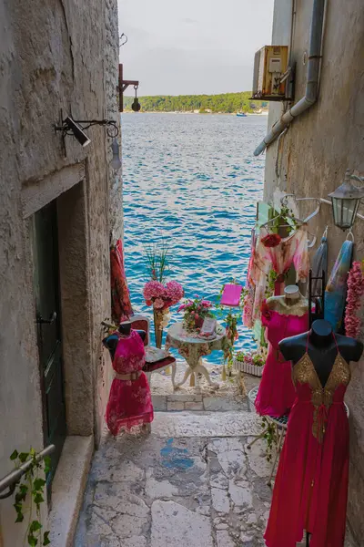 stock image Winding down a charming cobblestone alley in Rovinj, colorful clothing hangs beside a scenic view of the sparkling sea, inviting visitors to explore the beauty of this coastal gem.