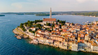 Akşam güneşi, büyüleyici sahil kasabası Rovinj 'in üzerine altın bir parıltı saçıyor. Titrek binaları, dingin rıhtımı ve ikonik kilise manzaranın üzerinde yükseliyor..