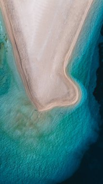 Parlak turkuaz dalgalar Brac Adası 'nın kumlu kıyılarına nazikçe vurarak rahatlamak için mükemmel bir kumsal oluşturuyor. Zlatni Rat Sahili Hırvatistan