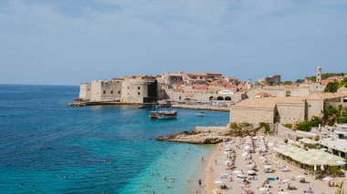 Canlı Dubrovnik Hırvatistan kıyı şeridi sıcak güneşin tadını çıkarırken, tarihi eski kasaba açık mavi gökyüzü altında pırıl pırıl parlıyor ve zengin bir miras ve çarpıcı bir mimari sergiliyor..