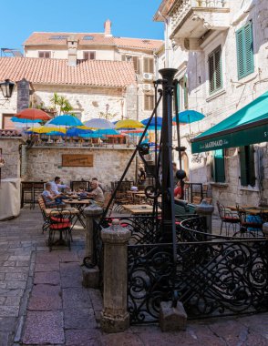 Kotor Montenegro 24 September 2024, Visitors enjoy coffee and local delicacies at charming outdoor tables, surrounded by Kotor historic architecture clipart