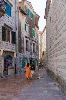 Gezginler, Kotor 'un dar ve kaldırımlı sokaklarını keşfeder. Etrafı, canlı kepenklerle süslenmiş antik taş binalarla çevrilidir. Güneş ışığı, tarihi kenti sıcak bir ışıltıyla yıkar..