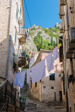 Kotor 'un tuhaf sokaklarında gezinirken, yukarıdaki canlı çamaşırları çırpınıyor, güneşin altında güneşleniyor. Antik taş binalar ve bereketli uçurumlar resim gibi atmosferi tamamlıyor..