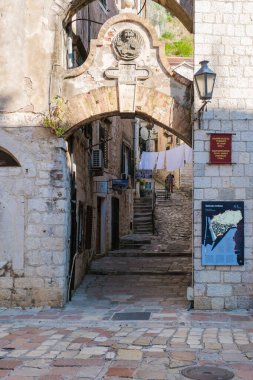 Kotor Montenegro 24 Eylül 2024, Kotor 'un büyüleyici caddelerinde dolaşırken antik taş kemerlerin tuhaf bir ara sokak oluşturduğu yerde. Güneş ışığı kaldırım taşlarının üzerinde dans eder