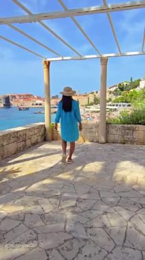 Hırvatistan 'ın tarihi Dubrovnik kenti yakınlarında sakin, pitoresk bir manzarada, mavi bornoz giymiş bir kadın zarif bir şekilde yürüyor ve rahatlamak için huzurlu ve mükemmel bir kaçış sağlıyor.