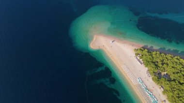 Hırvatistan 'ın Brac Adası' ndaki Zlatni Rat Sahili 'nin nefes kesici hava manzarasını deneyin. Kristal berrak sularını ve yemyeşil sularını sergiliyor. Unutulmaz bir kaçış için mükemmel.