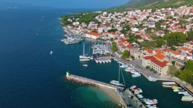 Hırvatistan 'ın Brac Adası' ndaki güzel Supetar Limanı 'nın nefes kesen sularının yanında canlı kıyı yaşamını gösteren nefes kesici hava manzarasını ele alalım.