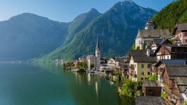 Görkemli dağların arasına yerleştirilmiş Hallstatt sergileri sakin göl boyunca büyüleyici evler