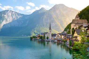 Yükselen dağların ortasında, büyüleyici evler göl boyunca canlı renklerle Hallstatt 'u dolduruyor. Altın güneş ışığı sakin sularda dans eder, alacakaranlıkta resim gibi bir yansıma yaratır..