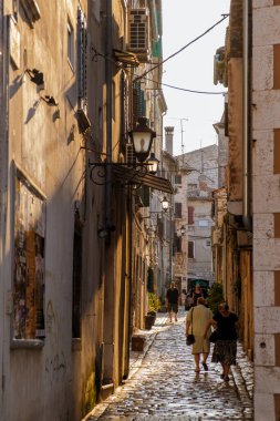 Rovinj Hırvatistan 27 Ağustos 2024 'te, güneş batarken, insanlar Rovinj' in büyüleyici dar sokaklarında dolaşarak, bu kıyı taşını tanımlayan canlı atmosferi ve büyüleyici mimariyi keşfediyorlar..