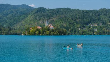 24 Ağustos 2024 'te Slovenya' da Bled Gölü 'nün çarpıcı mavi sularında süzülerek süzülürken, yemyeşil tepeler ve pitoresk bir ada tarafından çerçevelendi.. 