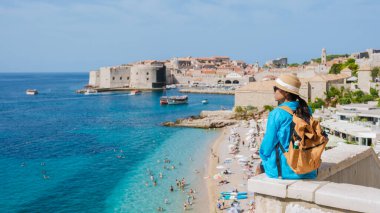 Hırvatistan 'ın Dubrovnik kentindeki canlı mavi sulara tek başına bakan bir gezgin. Kumsala gidenler kumlu kıyılarda günlerinin tadını çıkarırken güneş ışıl ışıl parlıyor yaz mutluluğunun özünü yakalıyor..
