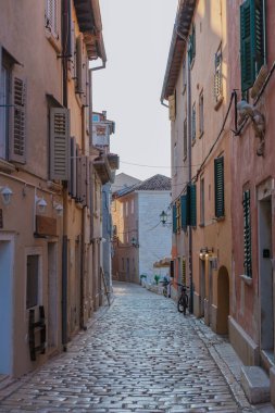 Rovinj 'in dar kaldırımlı caddelerinde gezinen ziyaretçiler, batan güneşin yumuşak parıltısıyla mükemmel bir şekilde aydınlanan pastel renkli binalardan ve eşsiz mimariden büyüleniyorlar..